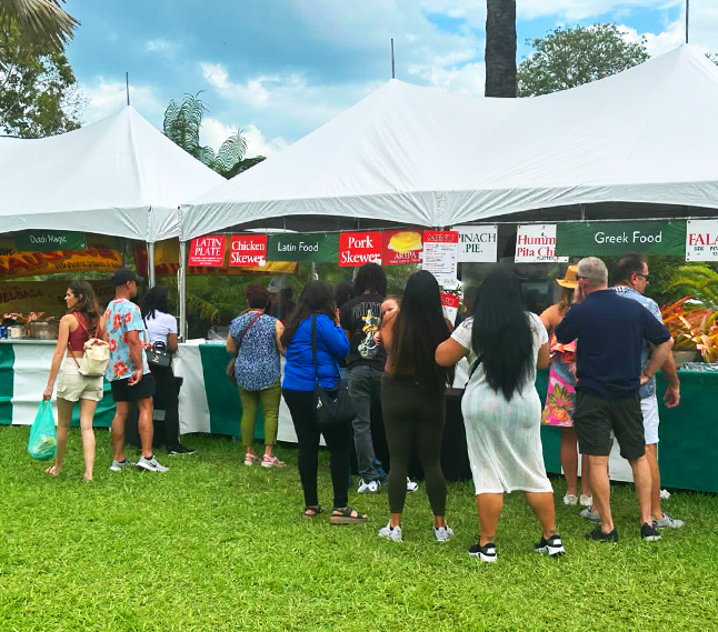 people standing on the grass in fornt of a garden tent